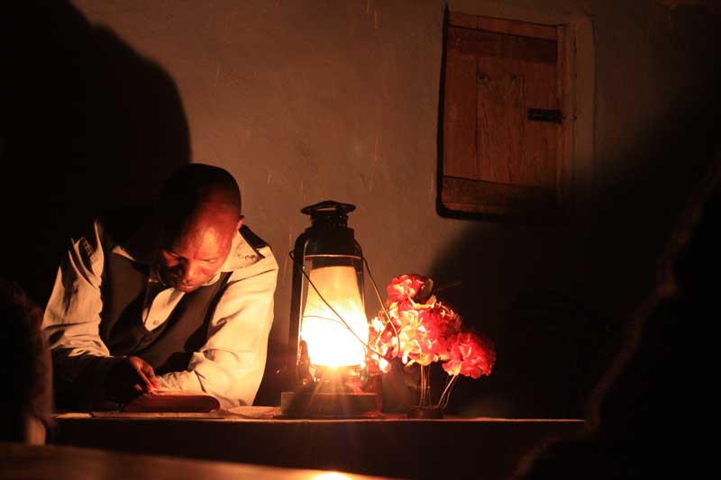 man reading by lantern at night